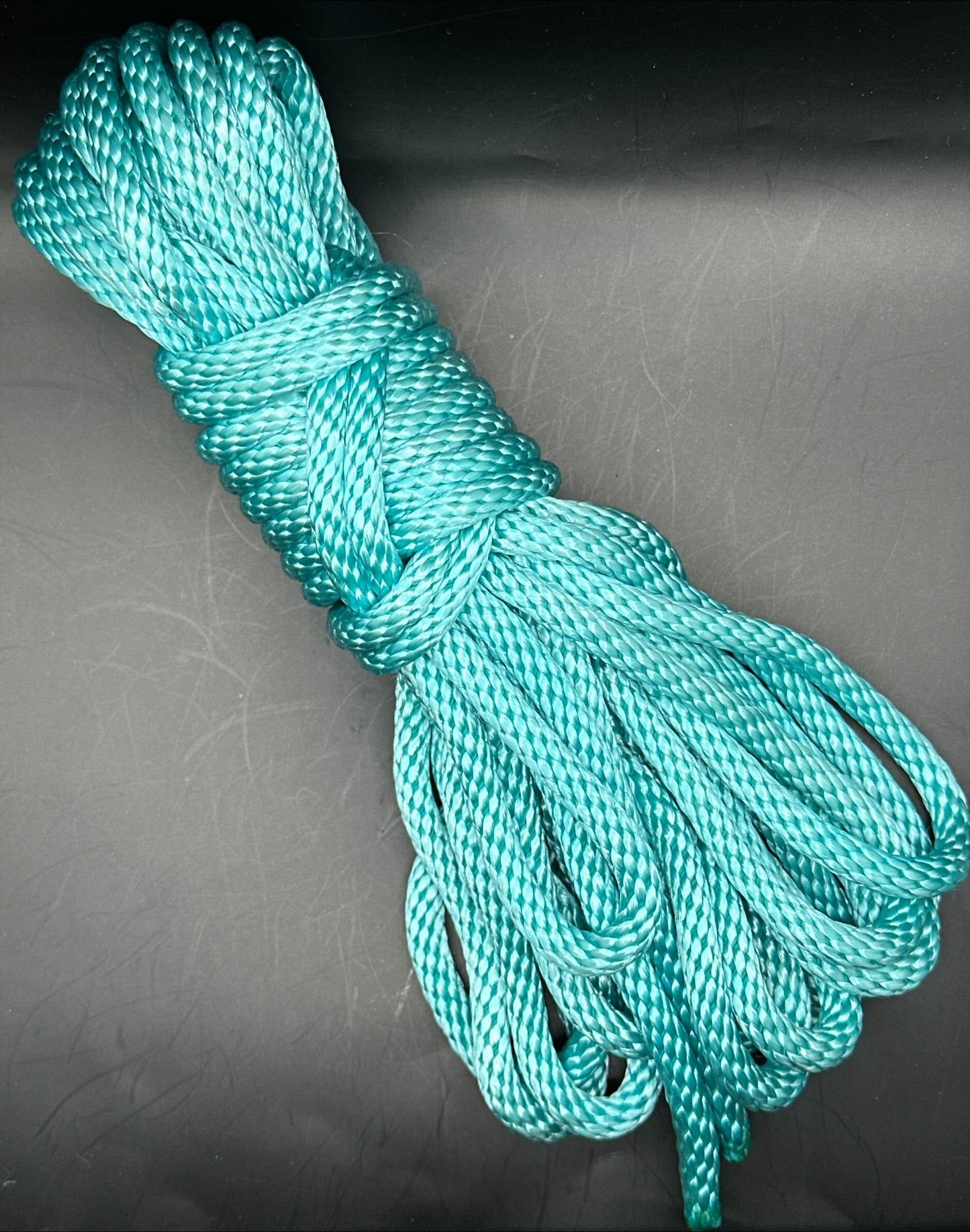30 ft nylon rope bundle in AquaKnot, a neon water blue glowing with vibrant aquatic shimmer under UV light.