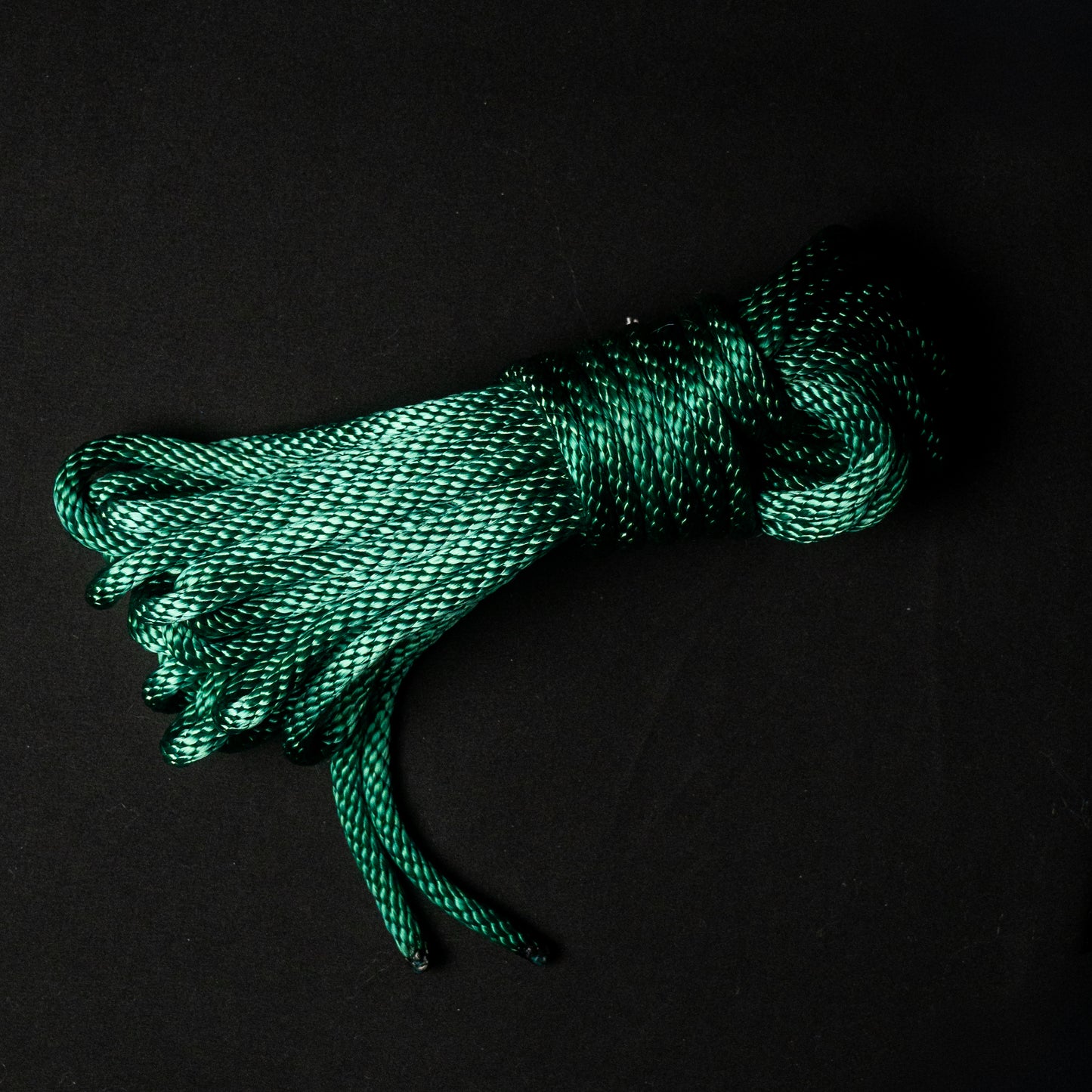 30 ft nylon rope bundle in Serpent Coil, a rich emerald green nylon rope with deep teal shadows and a subtle metallic shimmer, with yellow undertones evoking the scales of a coiled serpent.
