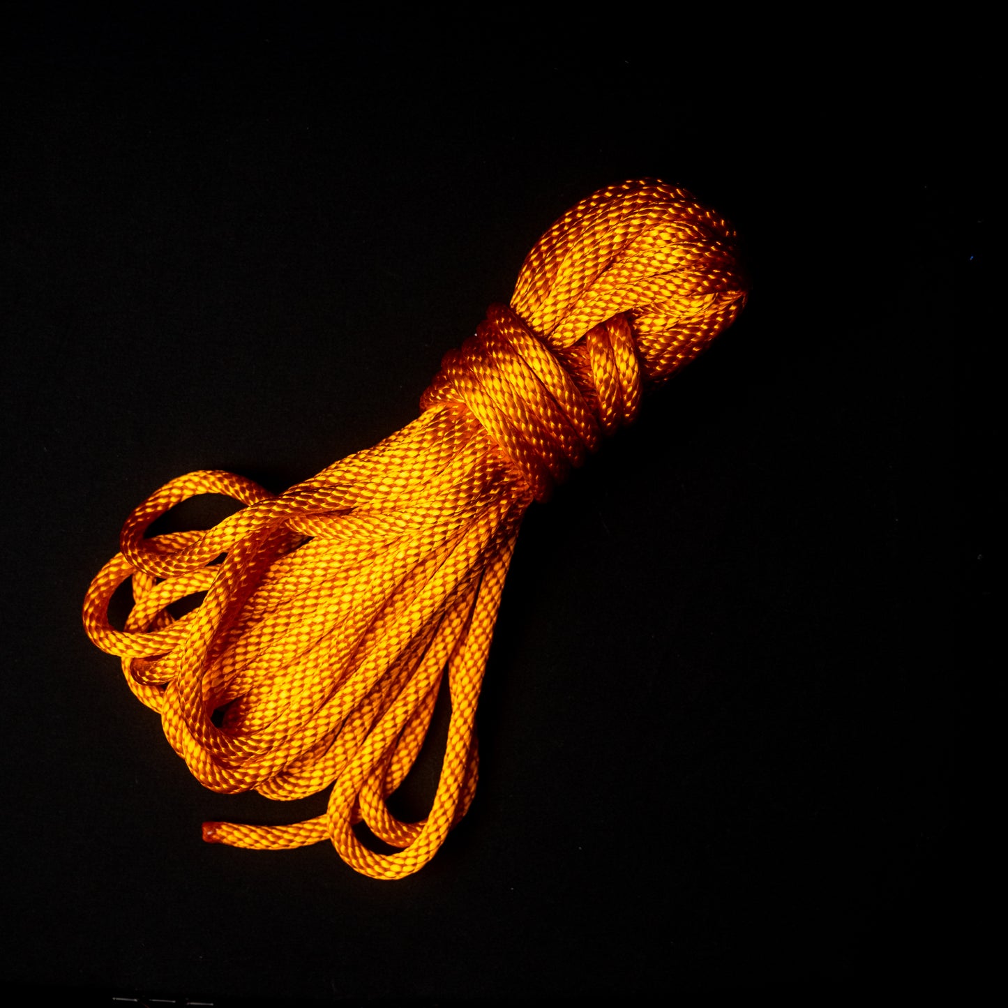 30 ft nylon rope bundle in Tangerine Tease, an electrifyingly radiant citrus orange that glows a fiery sunset yellow orange under black light.