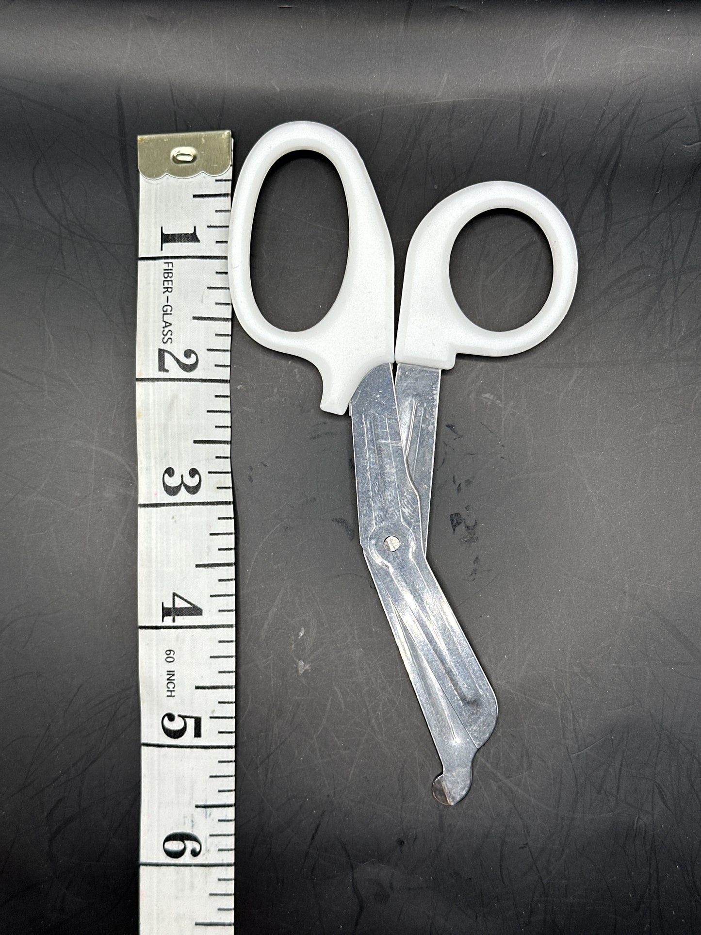 Emergency Scissors/Safety Shears: This White pair is 5.7" long, made with stainless steel and designed for first aid use to cut through thicker materials - it works on our rope, we tried it!